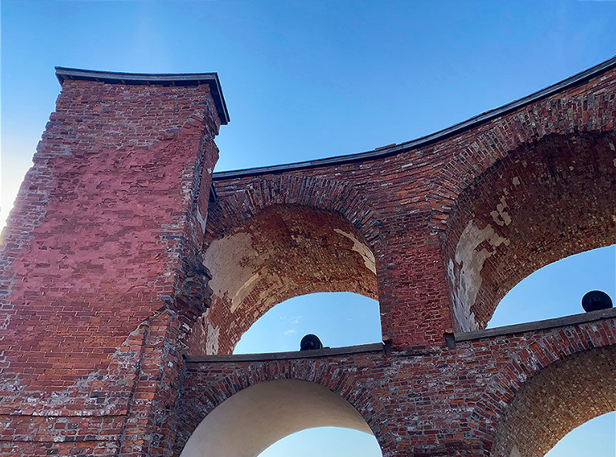 The top arches of Bomarsund Fortress in Åland against a clear blue sky.